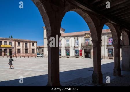 I visitatori passeggiano attraverso la piazza principale di Medinaceli, ammirando l'architettura del Palazzo Ducale sotto un cielo azzurro. Foto Stock