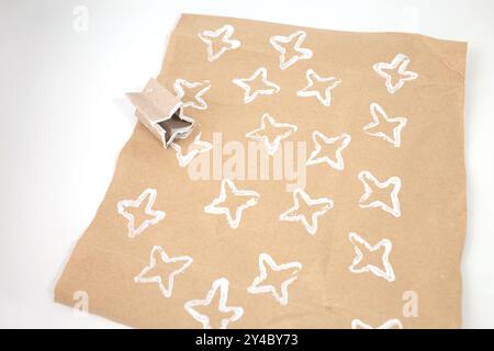 Attività facile per bambini, come realizzare carta da imballaggio personalizzata, carta marrone con motivi bianchi, rotolo di carta igienica piegato, Foto Stock