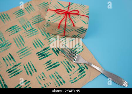 Esercitazione sui francobolli decorativi con forchetta nella vernice e fogli di carta. Crea carta da imballaggio unica e progetti fai-da-te per progetti personalizzati. CH Foto Stock