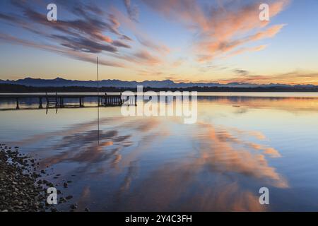 Montagne che si riflettono nel lago, atmosfera serale, atmosfera nuvolosa, inverno, passerella, lago Starnberg, Alpi bavaresi dietro, Baviera, Germania, Europa Foto Stock