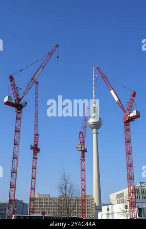 La famosa torre della televisione di Berlino con quattro gru a torre rosse Foto Stock