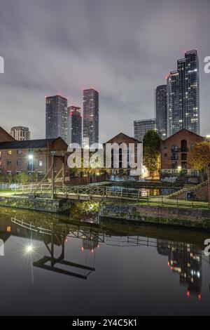 Castlefield storico di Manchester di notte con lo skyline moderno sullo sfondo Foto Stock