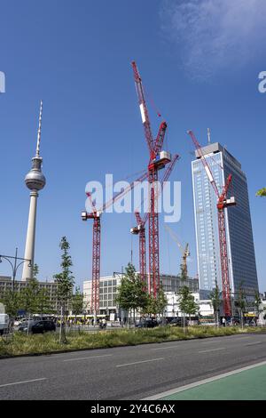 La famosa Alexanderplatz di Berlino con la torre della televisione e quattro gru da costruzione rosse Foto Stock