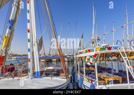 Barche turistiche Egiptiane ormeggiate sulla riva del Nilo, Luxor Foto Stock