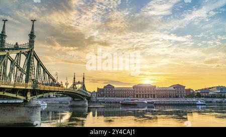 Liberty Bridge e barche turistiche a Budapest all'alba Foto Stock