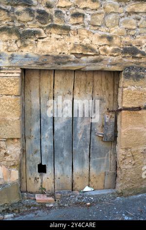 Porta in legno invecchiato in una casa in pietra. El Frago, Saragozza, Spagna Foto Stock
