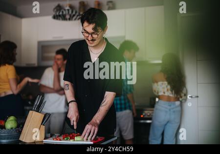 Giovani amici che si godono una festa di cucina in un'accogliente cucina Foto Stock