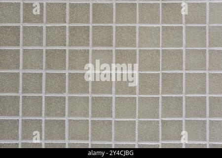 Sfondo costituito da un muro di piastrelle a mosaico beige Foto Stock