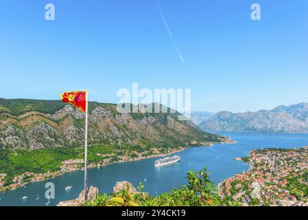 Bandiera sulle mura in rovina dell'antica fortezza di Cattaro, Montenegro. Vista aerea Foto Stock