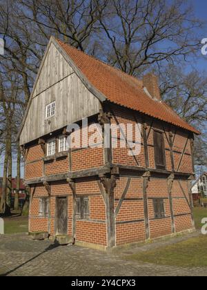 Una casa ben conservata e mezza in legno con mattoni rossi ed elementi di legno sorge in un villaggio, wuellen, muensterland, detuschland Foto Stock