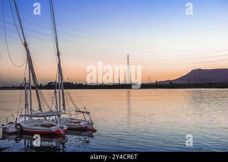 Barche a vela ormeggiata sul fiume Nilo a Luxor al tramonto Foto Stock