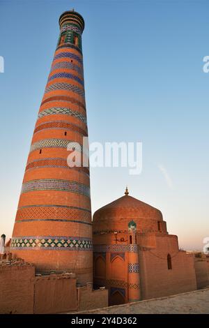 Minareto Islam Khodja al tramonto a Itchan Kala, antica città interna della città vecchia di Khiva nella regione di Khorzem, Uzbekistan Foto Stock