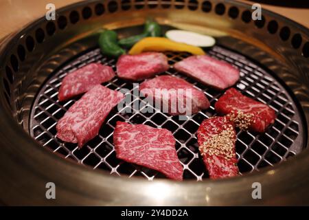 Un primo piano di costolette di manzo Wagyu alla griglia su un tradizionale barbecue giapponese Yakiniku. Foto Stock