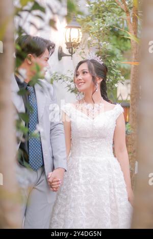 un paio di uomini e donne posano elegantemente guardandosi romanticamente e intimamente indossando bei vestiti in un parco, sposa nazionale all'aperto Foto Stock