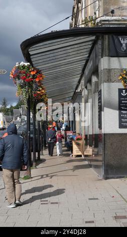 Baldacchino in ferro battuto e cesti sospesi su Pitlochry Atholl Road Foto Stock