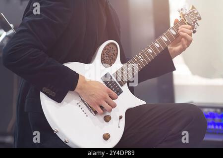 Mani di un uomo che suona una chitarra elettrica in una band sul palco, intrattenimento di un chitarrista artista con il suo strumento musicale. Musica Foto Stock