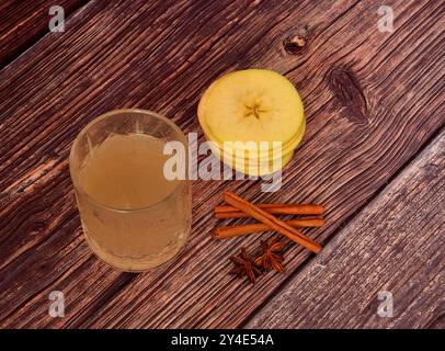 Liquore di mele con cannella e anice su sfondo nero, alcol fatto in casa, spezie e frutta matura. Primo piano. Foto Stock