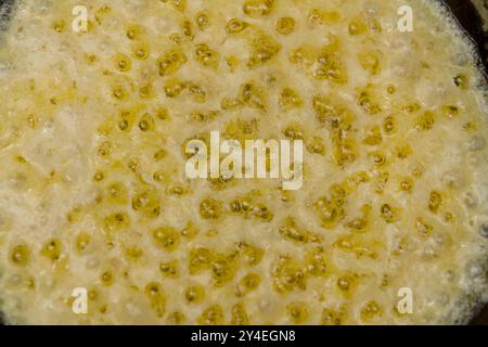 Primo piano di ghee bollenti in una padella, perfetto per gli sfondi culinari Foto Stock