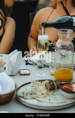 Versare a mano il vino sui bicchieri da vicino, il cameriere versa vino frizzante rosa Foto Stock