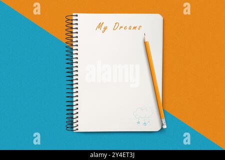 Sopra il libro di testo da vicino, accompagnato da una matita su uno sfondo geometrico colorato, che simboleggia sogni, creatività e concetto di intenzione Foto Stock