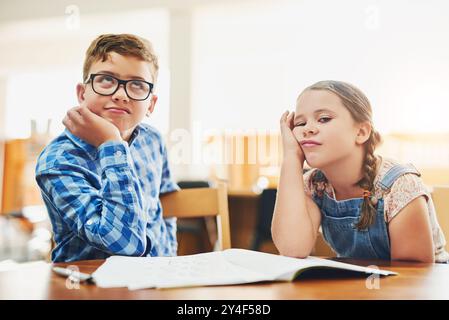 Annoiato, notebook e ritratto dei bambini in classe con bassa motivazione, affaticamento e pigro per l'apprendimento. Istruzione, studenti stanchi e bambini con adhd Foto Stock