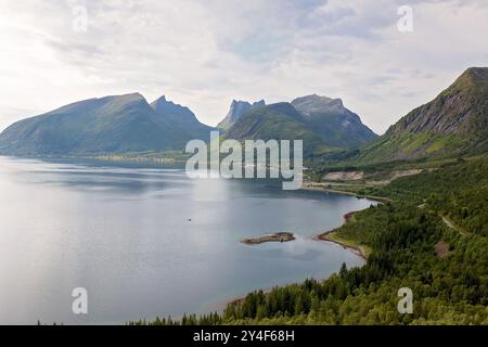 I bambini, in piedi sul bordo di una piattaforma panoramica lunga 44 metri, si affacciano sull'acqua del Bergsfjord, godendosi la vista sull'isola di Senja, nord nord nord Foto Stock