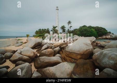 Casa di luce sull'isola di Lengkuas con caratteristiche rocce di granito situata nelle isole Belitung dell'Indonesia Foto Stock