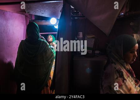 Gibuti: Atmosfera nella città vecchia, cabina fotografica in via "rue de Paris", donna velata che ritocca il trucco davanti a uno specchio prima di un ritratto Foto Stock