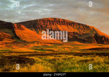 Il Trotternish Ridge, un'importante scarpa lavica e sedimentaria e sito panoramico nel lontano ne al tramonto. Flodigarry, Trotternish, Skye, Ebridi, Scozia, REGNO UNITO Foto Stock