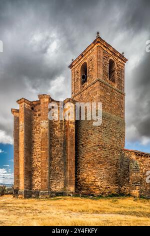 La chiesa gotica di Nuestra Señora del Rosario si erge orgogliosamente nel borgo di Gallinero, circondata da cieli suggestivi e paesaggi panoramici. Foto Stock