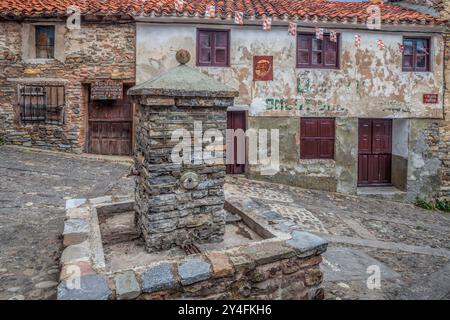 Esplora le pittoresche strade di Yanguas a Soria, con antiche case in pietra e una pittoresca fontana circondata dalla storia. Foto Stock