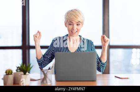 Allegra Business Lady Che Scuote I Fists Celebrando Il Successo In Ufficio Moderno Foto Stock
