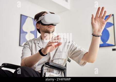 Ritratto di un uomo con disabilità che utilizza la tecnologia VR e interagisce con opere d'arte digitale invisibili in un museo d'arte moderna Foto Stock