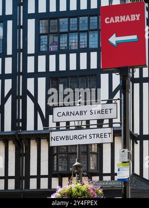Indicazioni stradali per Carnaby Street e Newburgh Street fuori dai grandi magazzini Liberty's Soho Londra Inghilterra Regno Unito Foto Stock