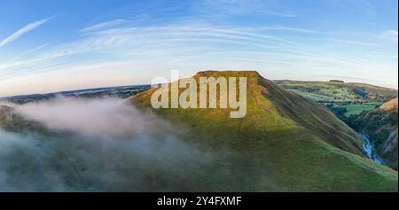 Il sole che sorge illumina il lato della nuvola di Thorpe mentre alcuni nebbiosi amano attraverso la valle sottostante, Dovedale, nel Peak District Derbyshire, Regno Unito. Foto Stock