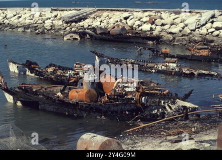 Prima guerra del Golfo: 8 marzo 1991 bruciato dall'esercito iracheno in fuga, la flotta di dhow distrutta del Kuwait raddoppia il vecchio porto delle navi a Kuwait City. Le barche da pesca in legno sono il simbolo nazionale del Kuwait. Foto Stock