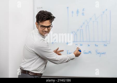 la foto di scorta cattura un serio uomo d'affari team leader che offre una presentazione sulle statistiche finanziarie durante una riunione di gruppo in una sala riunioni Foto Stock