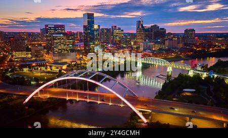 Vista aerea dello skyline illuminato di Nashville e del ponte al crepuscolo Foto Stock