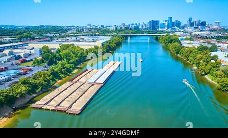 Vista aerea delle chiatte sul fiume e dello skyline della città in movimento Foto Stock