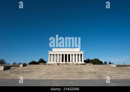 WASHINGTON DC, Stati Uniti: Una vista grandangolare del lato orientale del Lincoln Memorial, con le sue colonne neoclassiche che si innalzano contro un cielo azzurro. Lo scatto cattura la grandezza del monumento dalla piazza, mostrando uno dei monumenti più iconici di Washington DC, progettato dall'architetto Henry Bacon e con una statua dello scultore Daniel Chester French. Foto Stock