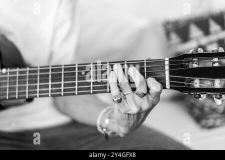 Vista dettagliata delle mani di una donna mentre suona la chitarra Foto Stock