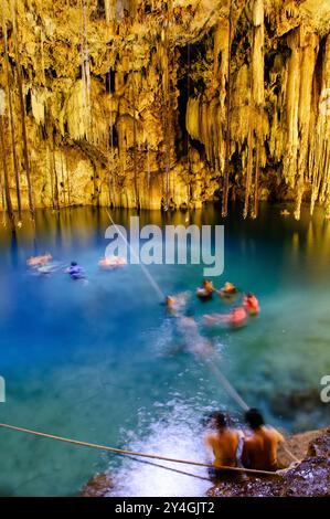 VALLADOLID, Messico - i nuotatori godono delle acque cristalline di Cenote X'kakah vicino a Valladolid (anche vicino a Dzitnup). Parte della rete massiccia dello Yucatan Foto Stock