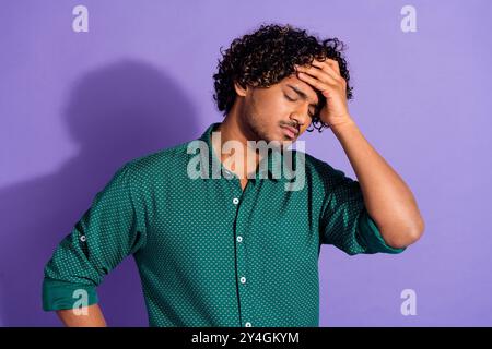 Foto ritratto di un giovane uomo d'affari indiano turbato oggi sovraccarico toccando la fronte sentire mal di testa isolato su sfondo di colore viola Foto Stock