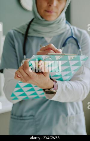 Medico curante che esamina le cartelle cliniche dei pazienti Foto Stock