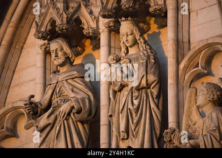 BRUXELLES, Belgio: Statue medievali in pietra adornano la facciata della cattedrale di San Michele e San Gudula, la cattedrale nazionale belga. Questi dettagli scultorei rappresentano parte del programma decorativo gotico di questo monumento religioso del XIII secolo. La posizione di rilievo e il patrimonio artistico della cattedrale riflettono il suo significato come sede delle cerimonie reali belghe. Foto Stock