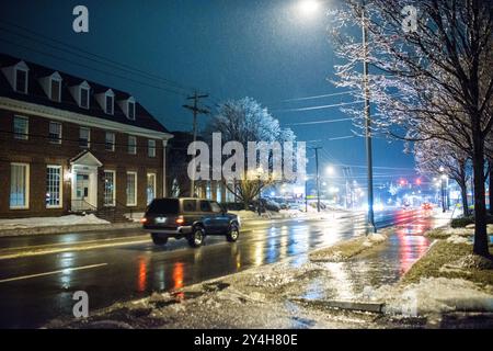 Di automobili che circolano sulle strade slick di notte in Arlington, VA, durante una tempesta di ghiaccio. Foto Stock