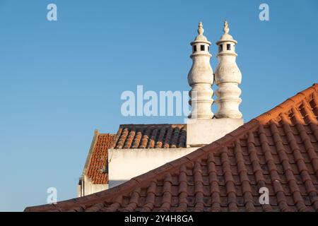 Dettaglio architettonico ravvicinato dei tetti e dei camini delle tradizionali case di strada nella piccola città di Vila Nova de Milfontes in Portogallo Foto Stock