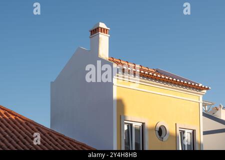 Dettaglio architettonico ravvicinato dei tetti e dei camini delle tradizionali case di strada nella piccola città di Vila Nova de Milfontes in Portogallo Foto Stock