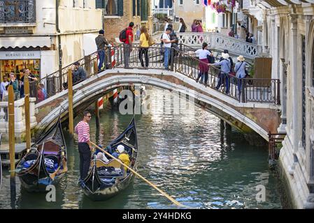 I turisti che prendono la gondola, la tradizionale barca veneziana, sul canale di Venezia, Italia, Europa Foto Stock