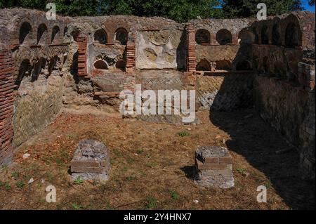 Via dei Sepolcri, risalente al II secolo d.C., a Ostia Antica, Italia. Qui i morti sono stati deposti in nicchie ad arco. Le pareti mostrano tecniche di costruzione romane, tra cui pareti con blocchi di pietra o mattoni a forma di piramide quadrati o disposti in una griglia diagonale. Foto Stock